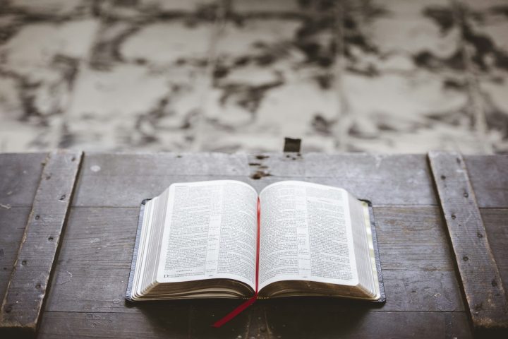 Closeup shot of an open bible on a wooden box with a blurred background